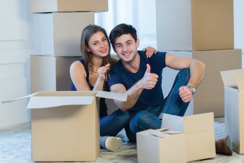 Movers carrying furniture through a shared staircase in a Crystal Palace block