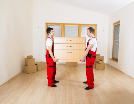 Office furniture being carried during a planned business move in Crystal Palace